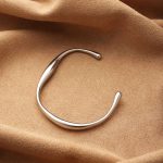 Silver Fluid Curve Stainless Steel Bangle – Modern Sculptural Style - Image 3